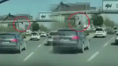 AFİŞ ASARKEN ÜST GEÇİTTEN DÜŞÜP ARABALARIN ALTINDA KALDI!